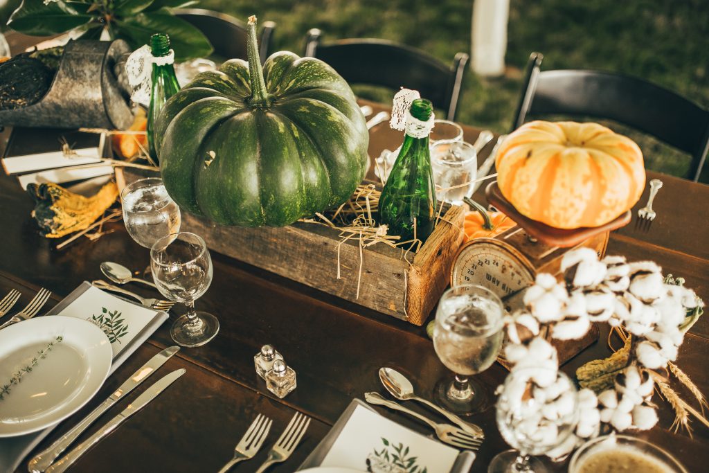 fall table centerpiece with green and orange pumpkins