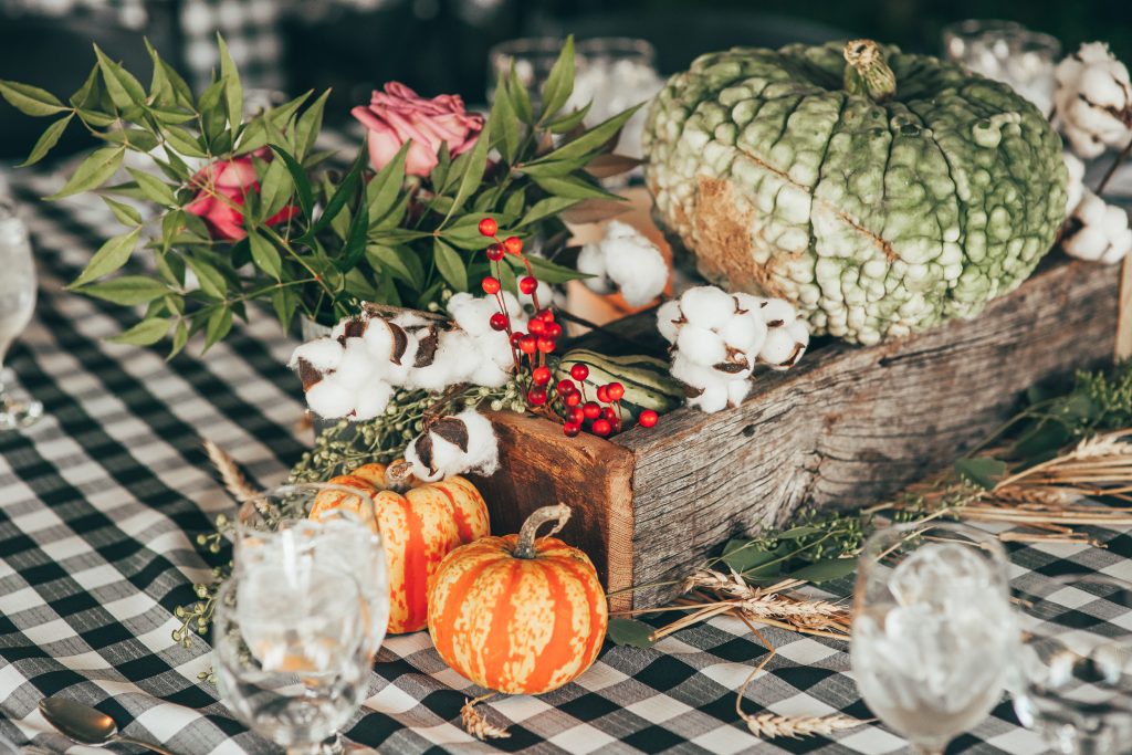close up of fall centerpiece with wooden box and small pumpkins