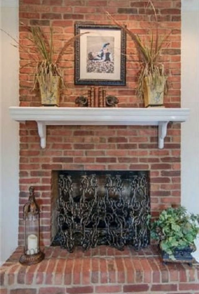 red brick fireplace with white mantel
